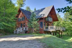 a large wooden house with a porch and a balcony at Spacious log cottage Resort access in Lac-Superieur