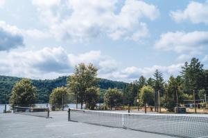 a tennis court with a net on top of it at Spacious log cottage Resort access in Lac-Superieur