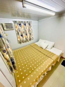 Habitación pequeña con cama con manta amarilla en Daily Bread Organic Farm & Resort, en Bustos