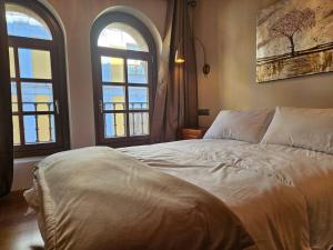 - une chambre avec deux fenêtres et un grand lit dans l'établissement 1A123 Exclusivo apto Céntrico by R2R Consulting, à Gijón