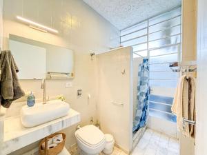 a bathroom with a sink and a toilet and a mirror at Apto vista mar em Pitangueiras, Guarujá in Guarujá +41 photos