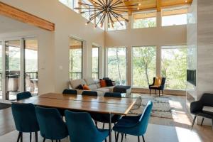 sala de estar con mesa de madera y sillas azules en Le Zen Belvédère, en Sainte-Adèle