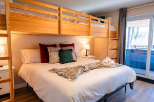 ein Schlafzimmer mit einem großen weißen Bett und einem Etagenbett in der Unterkunft Le Zen Belvédère in Sainte-Adèle