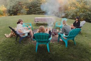 a group of people sitting around a fire at SPA private pond and beach volleyball in Lac-Superieur