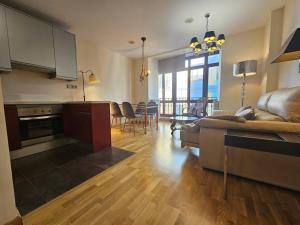 une cuisine et un salon avec un canapé et une table dans l'établissement 1A123 Exclusivo apto Céntrico by R2R Consulting, à Gijón