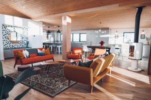 a living room with couches and a dining room and a kitchen at Lakeview Mid Century Luxury Cottage in Sainte-Adèle