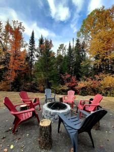 a group of chairs sitting around a fire pit at Le Mésangeai in Lac-Superieur