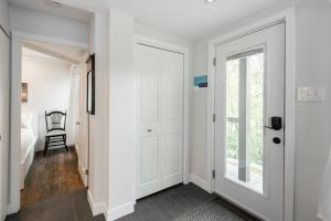 a hallway with white walls and a door at Le P'tit Caché 4 min de Ski Tremblant in Mont-Tremblant