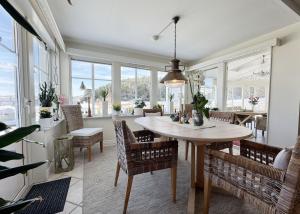 a dining room with a table and chairs and windows at Exclusive villa with sea view in Uddevalla in Uddevalla