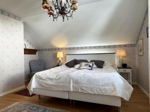 a bedroom with a white bed and a chandelier at Exclusive villa with sea view in Uddevalla in Uddevalla