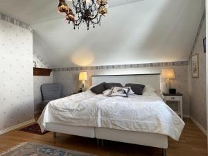 1 dormitorio con cama blanca y lámpara de araña en Exclusive villa with sea view in Uddevalla, en Uddevalla