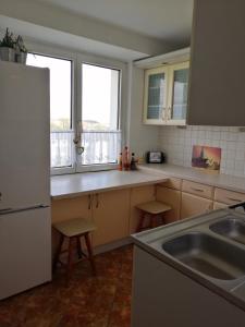 a kitchen with a sink and two windows at Wygodny i Funkcjonalny in Gdynia