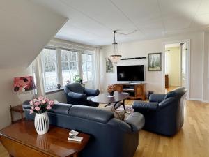 a living room with blue couches and a table at Exclusive villa with sea view in Uddevalla in Uddevalla