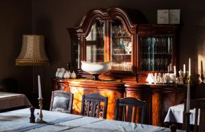 a wooden china cabinet with a table and a lamp at Villa Pepita in Miedzygorze