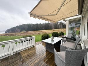 um pátio com uma mesa, cadeiras e um guarda-sol em Exclusive villa with sea view in Uddevalla em Uddevalla