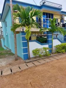 克里比的住宿－Residence djob，一座棕榈树的蓝色房子