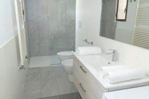 een witte badkamer met een toilet en een wastafel bij LO3 • [Navigli] Chic Apartment • in Milaan