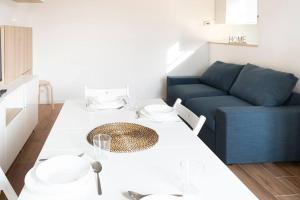 een woonkamer met een tafel en een blauwe bank bij LO3 • [Navigli] Chic Apartment • in Milaan