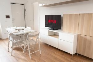een witte tafel en stoelen met een televisie op een aanrecht bij LO3 • [Navigli] Chic Apartment • in Milaan