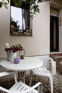 einen weißen Tisch und zwei Stühle auf einer Terrasse in der Unterkunft Ferienwohnung am Auensee in Leipzig