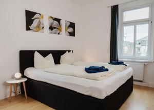 Una cama grande con sábanas blancas y toallas azules. en Apartmenthaus Sternstraße en Dresden