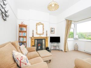 a living room with a couch and a fireplace at Lowena Cottage in Looe