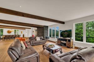 a living room with leather couches and a tv at Lazy Bear Lake House in Labelle