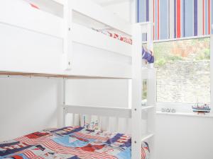 a white bunk bed in a room with a window at Lowena Cottage in Looe