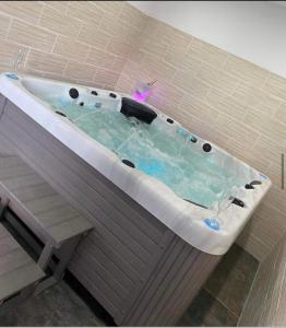 eine Whirlpool-Badewanne in einem beige gefliesten Badezimmer in der Unterkunft Le Paradise in Ville-le-Marclet