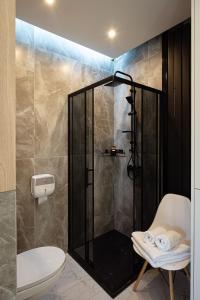 a bathroom with a shower with a toilet and a chair at Apartament Skandynawia in Ustroń