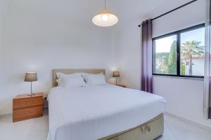 a white bedroom with a large bed and a window at AL - Sol Nascente ll Apartamentos in Vilamoura +36 photos