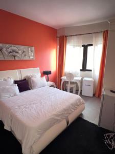 sypialnia z dużym łóżkiem i czerwoną ścianą w obiekcie COMPLEXE BLUE PHOENIX w mieście Dakar