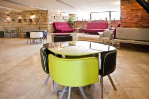 a restaurant with a table and green chairs at Hotel Club Ramon in Mitzpe Ramon
