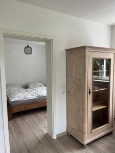 a bedroom with a bed and a wooden cabinet at Apartment Ida in Viereth-Trunstadt
