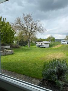 a view of a yard with a trailer and a tree at Apartment Ida in Viereth-Trunstadt