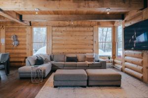 a living room with a couch and a tv at Corpo Big Group or Family 20 people 2 properties in Lac-Superieur