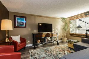 a living room with a flat screen tv and a red couch at #StayInMyDistrict Eclectic Boise Townhouse near St Als in Boise