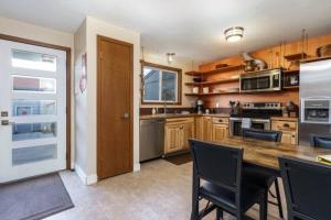 a kitchen with wooden cabinets and a wooden table at #StayInMyDistrict Eclectic Boise Townhouse near St Als in Boise