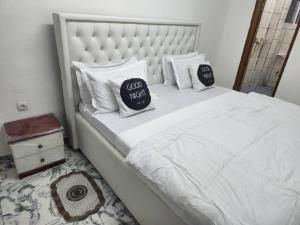 - un lit blanc avec 2 oreillers dans l'établissement Chambre Meublée à Douala, Bonapriso - Armée del'air, à Douala
