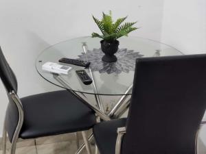 a glass table with a laptop and a plant on it at Chambre Meublée à Douala, Bonapriso - Armée del'air in Douala
