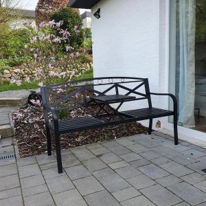 a black bench sitting in front of a house at Ferienwohnung an der Trave in Bad Segeberg