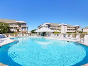 una grande piscina blu con sedie e condomini di Romar Lakes 302-B a Orange Beach