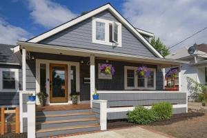 une maison avec une véranda à l'avant ornée de fleurs violettes dans l'établissement #StayInMyDistrict St Johns Walk to dining & shops, à Portland