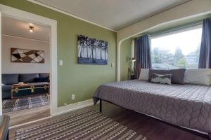 a bedroom with a bed and a large window at #StayinMyDistrict Historic Apartment Near Downtown in Coos Bay