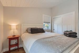 um quarto branco com uma cama e uma mesa com um candeeiro em Berkeley Hidden Gem 1BR Full Kitchen w Patio em Denver