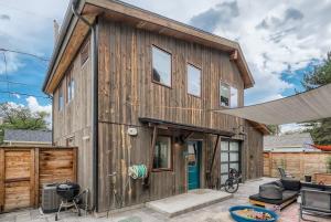 ein Holzhaus mit einer Terrasse und einem Zaun in der Unterkunft Berkeley Hidden Gem 1BR Full Kitchen w Patio in Denver
