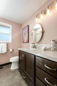 a bathroom with a sink and a toilet and a mirror at #StayInMyDistrict Cozy Central Boise Townhouse in Boise +37 photos
