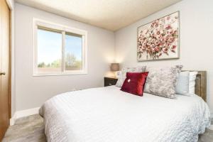a bedroom with a white bed with a red pillow at #StayInMyDistrict Cozy Central Boise Townhouse in Boise