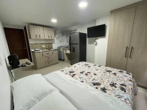 um quarto com uma cama e uma cozinha com um frigorífico em Apartaloft en el centro 302 em Pereira