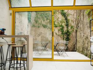 uma porta de vidro que leva a um pátio com mesas e cadeiras em Studio cosy hypercentre Terrasse em Blois